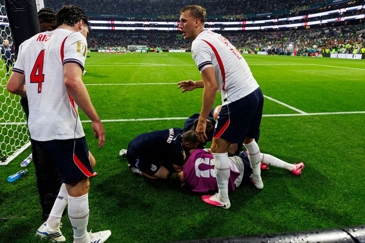 Declan Rice (L) and Dan Burn of England (R) try to help their teammate Jordan Henderson