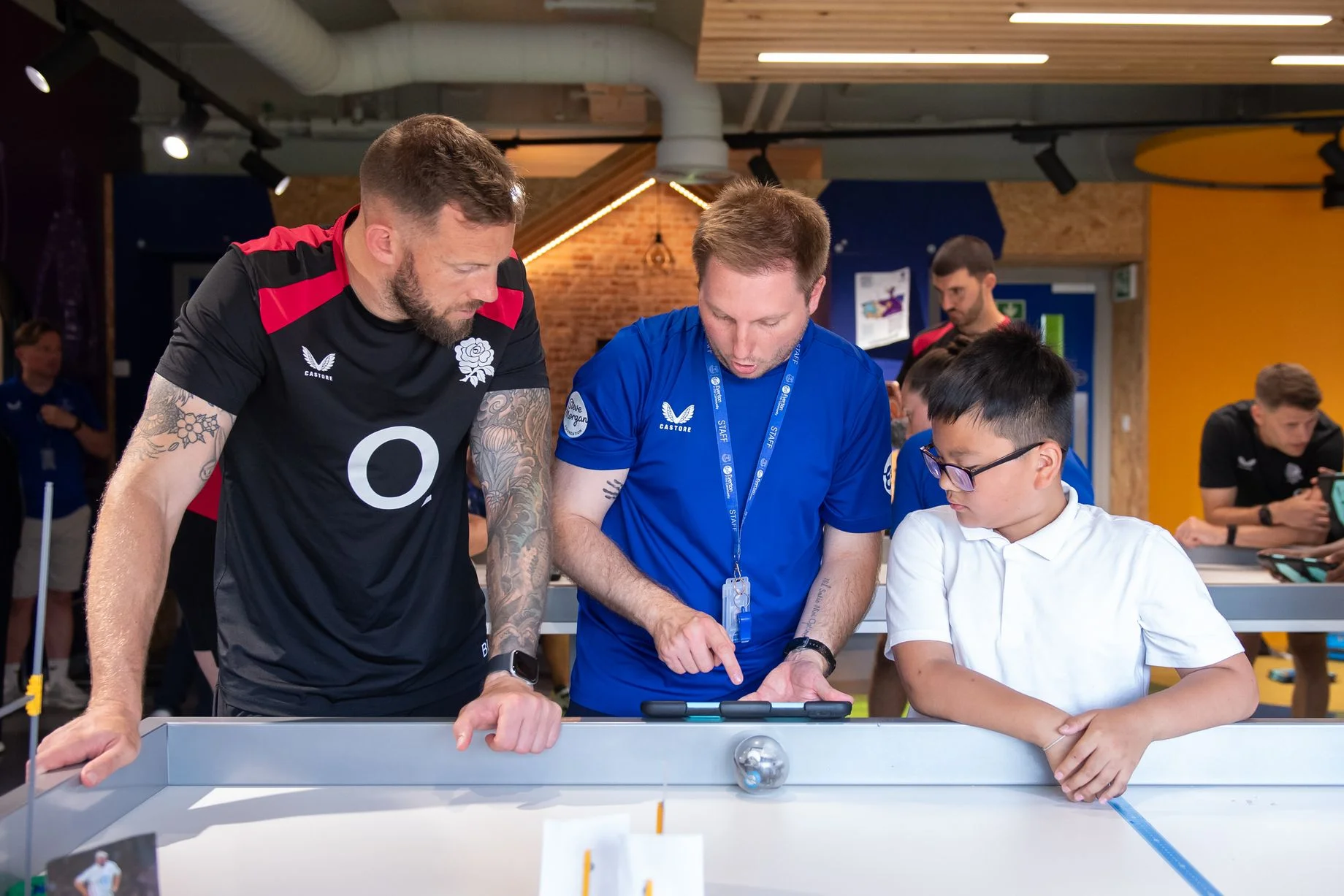 England rugby union coach Byron McGuigan learns about the digital skills lab from an Everton in the Community staff member